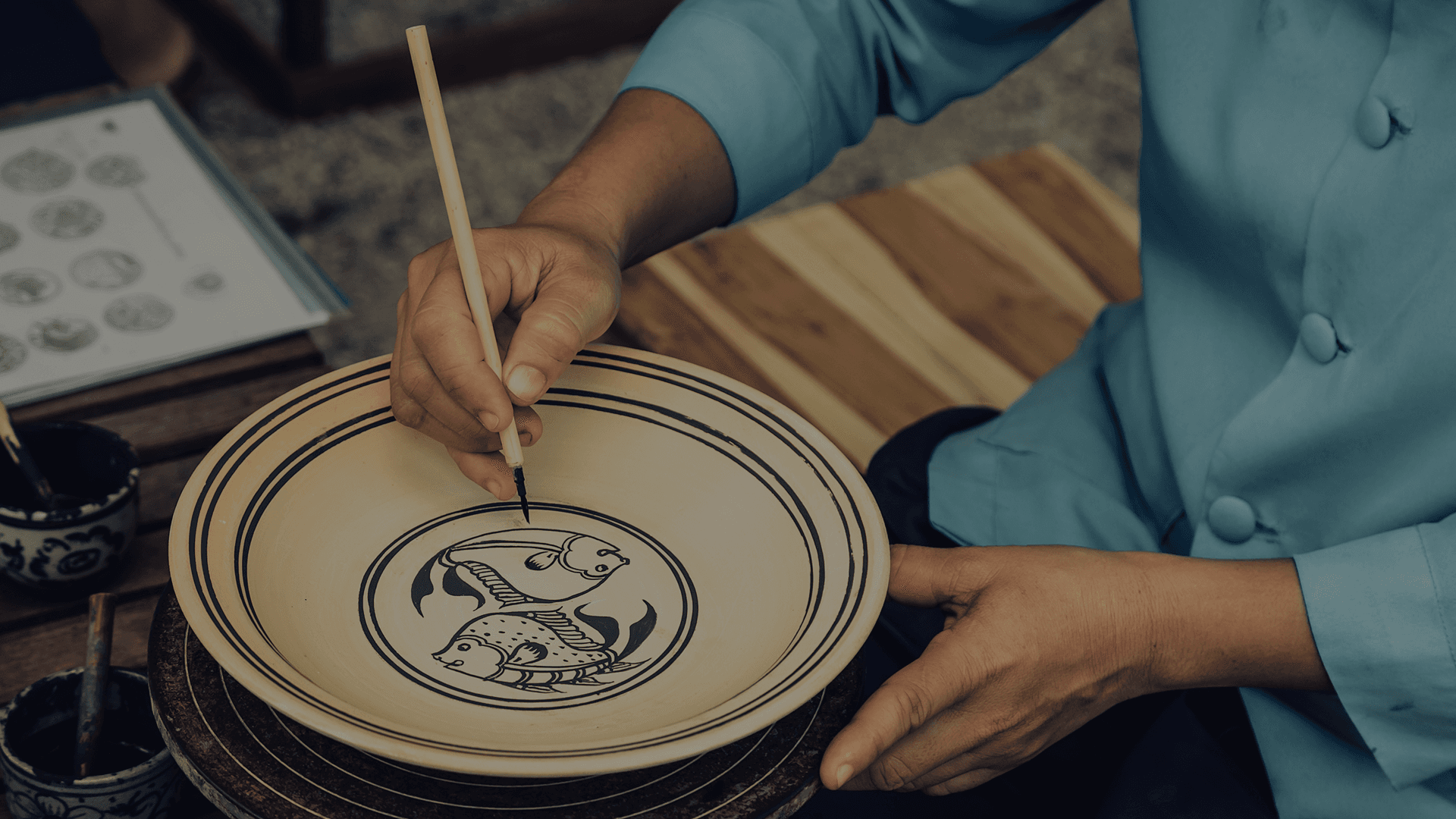 Artisan hand-painting a ceramic plate, reflecting IHCL Tata’s craftsmanship and heritage.